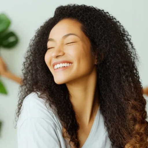 

A woman with long, healthy hair, smiling while massaging a scalp scrub into her scalp.