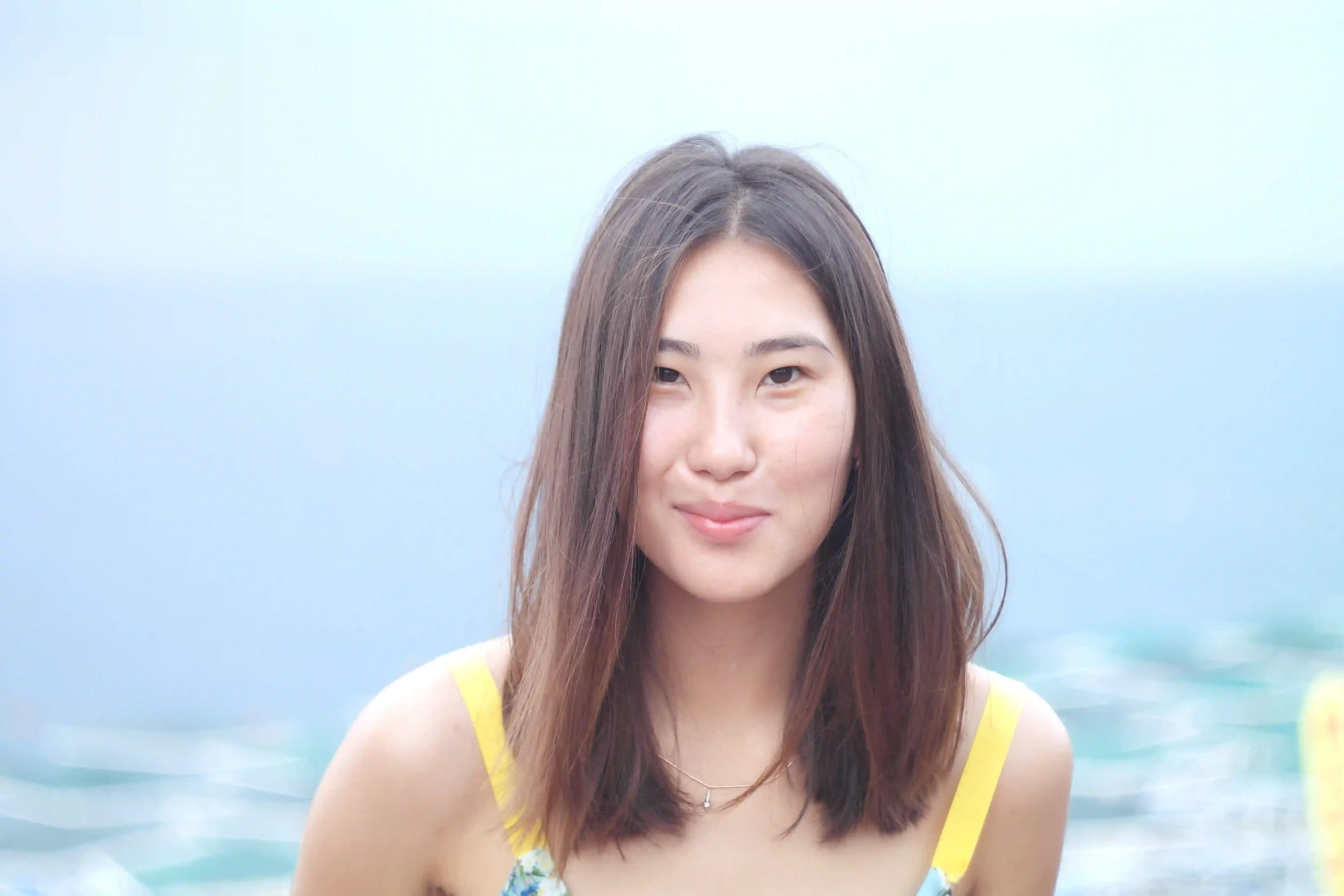 

A woman with long, healthy-looking hair, smiling and looking into the camera.